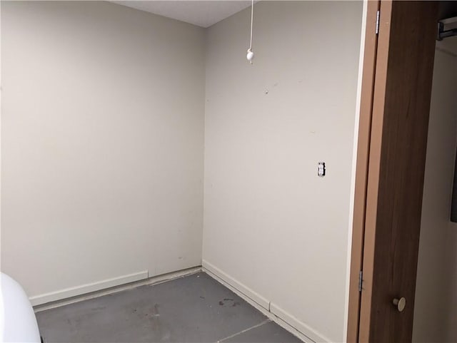 empty room with baseboards and concrete floors