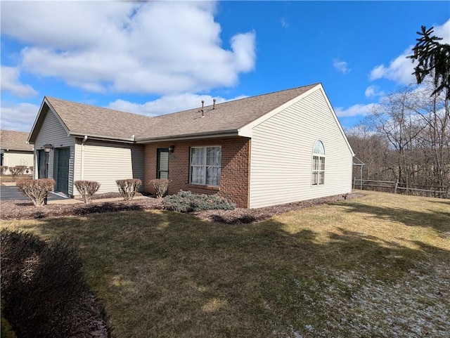 view of front of house featuring a front lawn, an attached garage, fence, and brick siding