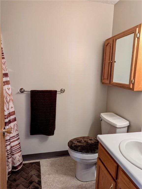 full bathroom featuring baseboards, toilet, and vanity