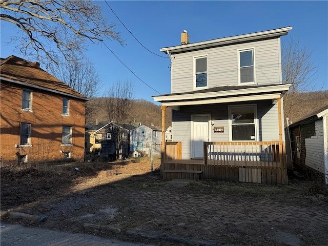 view of front of property with a porch and a chimney