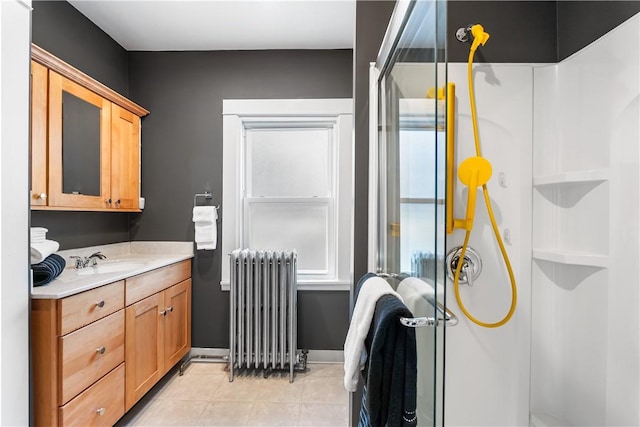 full bathroom with radiator, baseboards, a stall shower, tile patterned floors, and vanity