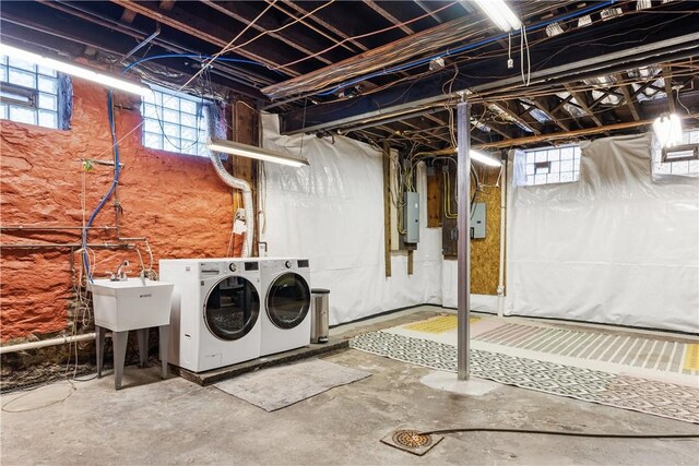 basement with electric panel, independent washer and dryer, and a sink