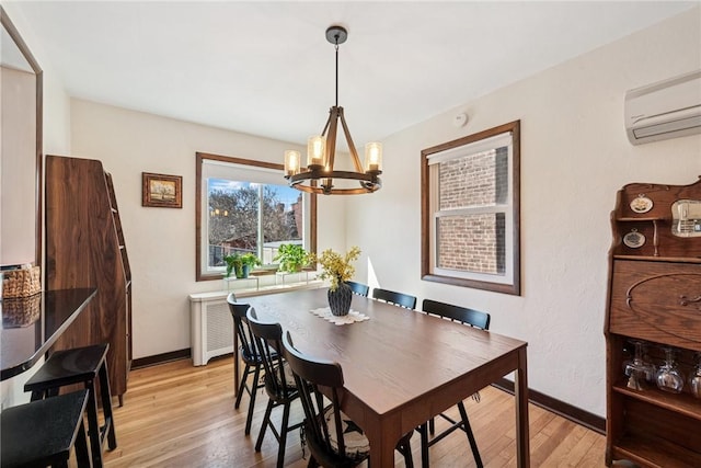 dining area with baseboards, light wood-type flooring, and a wall mounted AC