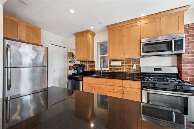 kitchen featuring a sink, decorative backsplash, appliances with stainless steel finishes, and recessed lighting