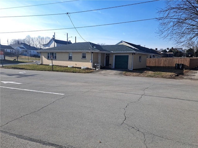 view of front of house featuring an attached garage and fence