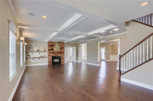 unfurnished living room featuring wood finished floors, baseboards, coffered ceiling, stairs, and beamed ceiling