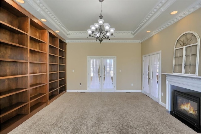 unfurnished living room featuring carpet flooring, french doors, a raised ceiling, and crown molding