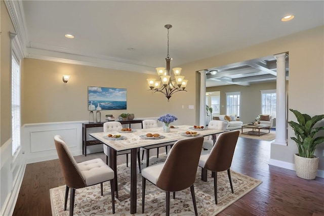 dining space featuring decorative columns, coffered ceiling, a wainscoted wall, and dark wood-style flooring