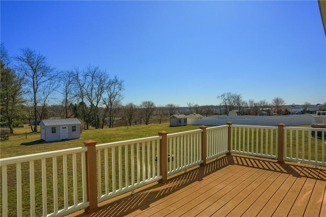 wooden deck with a storage shed, an outbuilding, and a yard