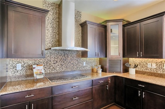 kitchen featuring black electric cooktop, backsplash, dark brown cabinetry, and wall chimney range hood