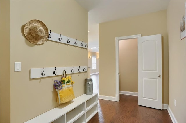 mudroom featuring dark wood-type flooring and baseboards