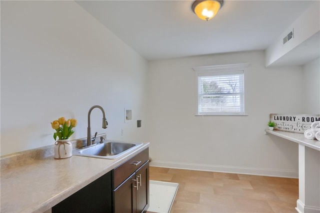 kitchen with light countertops, baseboards, visible vents, and a sink