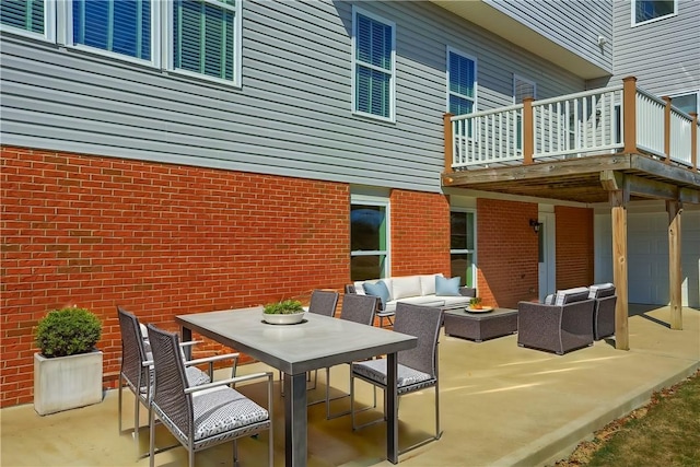 view of patio / terrace with an outdoor living space, an attached garage, outdoor dining area, and a balcony