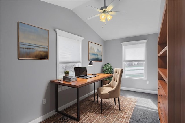 carpeted office space featuring lofted ceiling, a ceiling fan, and baseboards