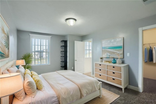 bedroom featuring dark carpet and baseboards