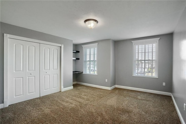 unfurnished bedroom with a closet, baseboards, and carpet