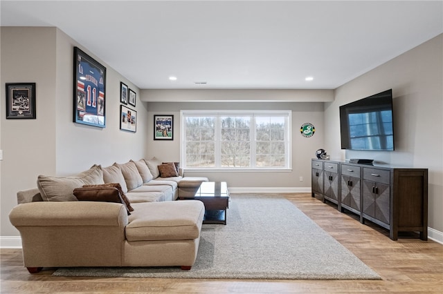 living area featuring recessed lighting, baseboards, and light wood-style floors