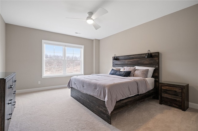 bedroom with visible vents, light colored carpet, baseboards, and ceiling fan