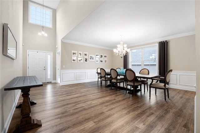 dining area featuring crown molding, dark wood-style flooring, and a chandelier