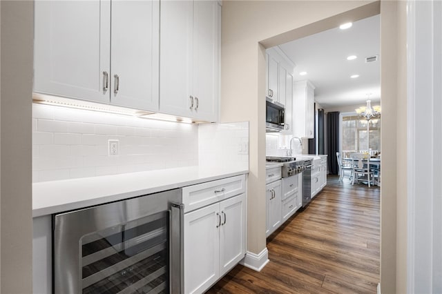 kitchen featuring beverage cooler, dark wood-style floors, stainless steel appliances, white cabinets, and light countertops