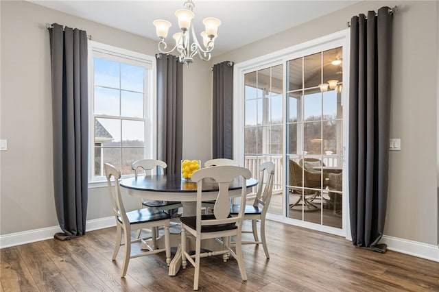 dining area featuring wood finished floors, baseboards, and a chandelier