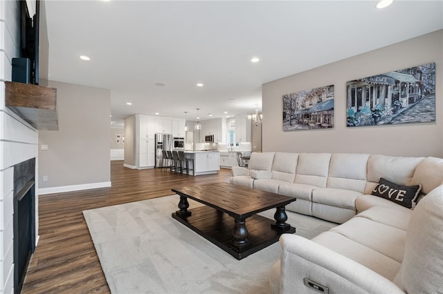 living area with recessed lighting, dark wood finished floors, and a fireplace