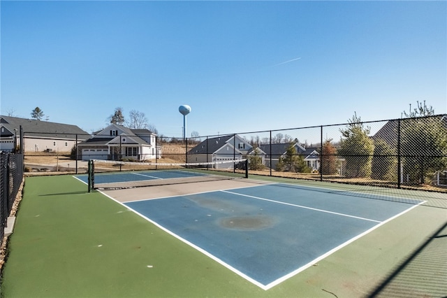 view of sport court with fence and a residential view