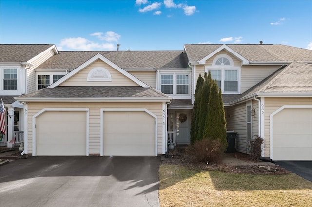 view of front of house featuring aphalt driveway, an attached garage, and a shingled roof