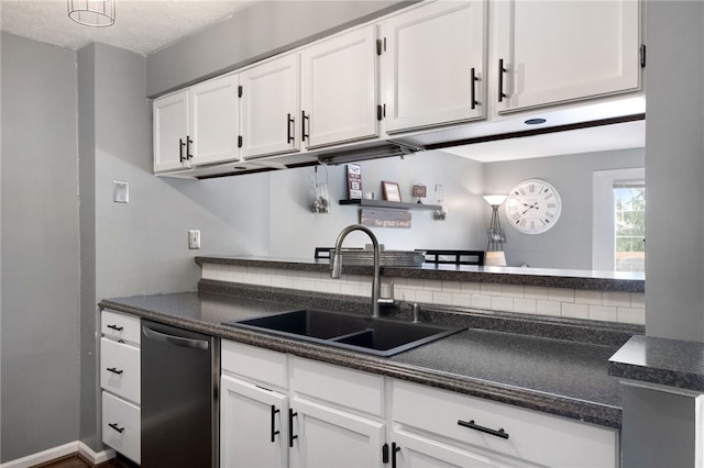 kitchen featuring dishwasher, white cabinetry, baseboards, and a sink