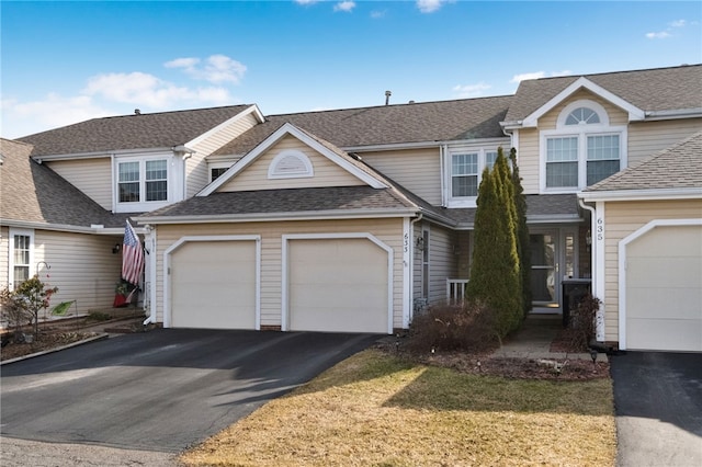 view of front of house with aphalt driveway, a garage, and a shingled roof