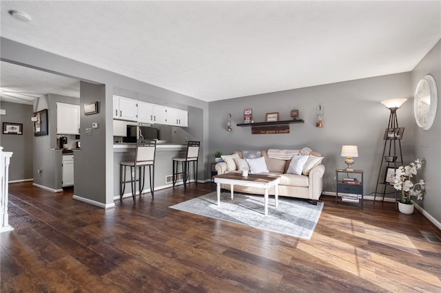 living area with dark wood finished floors and baseboards