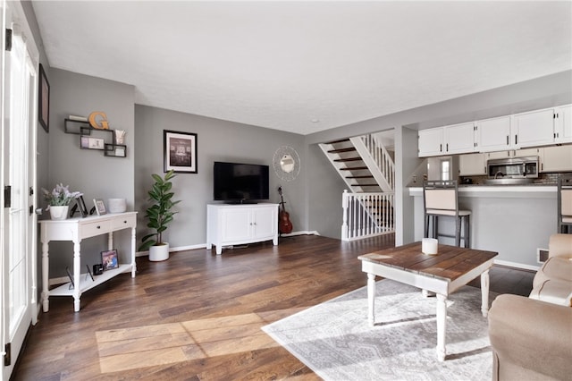 living area featuring stairway, baseboards, and wood finished floors