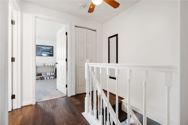 hallway featuring an upstairs landing and dark wood finished floors