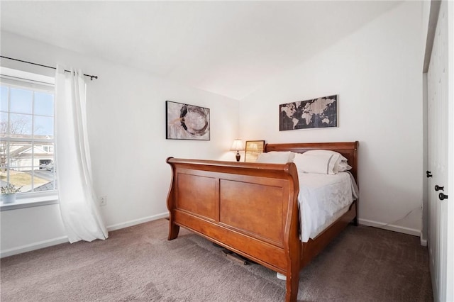 carpeted bedroom with lofted ceiling and baseboards