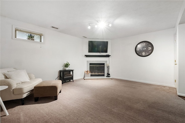 sitting room featuring visible vents, carpet floors, baseboards, and a premium fireplace