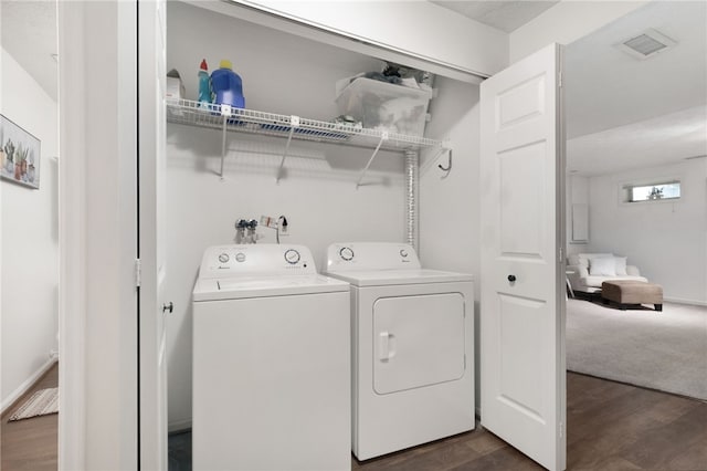 washroom featuring visible vents, dark wood-style floors, washing machine and dryer, and laundry area