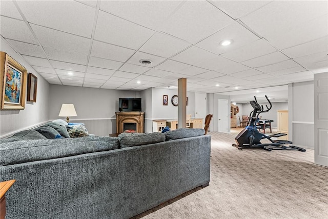 living area with a drop ceiling, recessed lighting, visible vents, and carpet floors