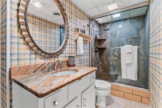 bathroom with vanity, wallpapered walls, tile patterned flooring, a shower stall, and toilet