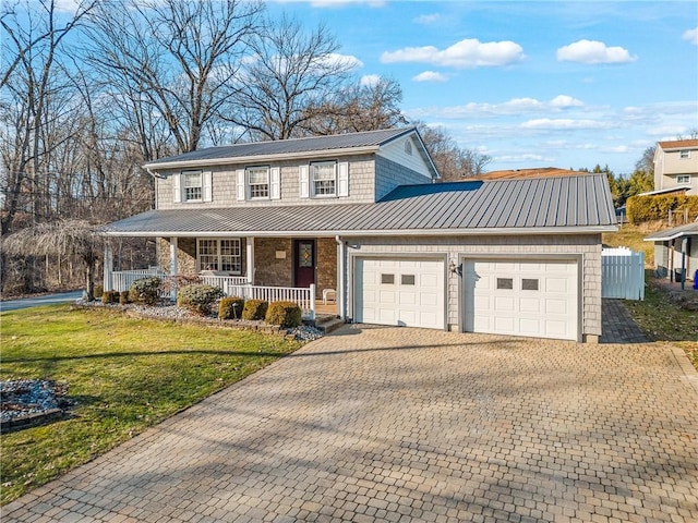 view of front facade with a standing seam roof, a porch, a garage, and metal roof