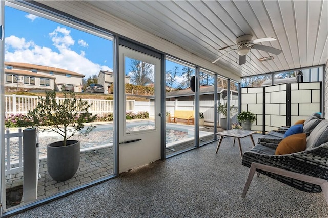 sunroom / solarium featuring a residential view, wooden ceiling, and ceiling fan