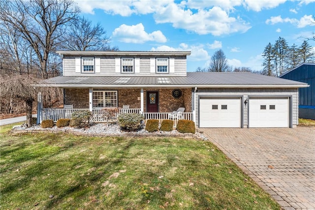 view of front of house with a front yard, an attached garage, covered porch, decorative driveway, and metal roof