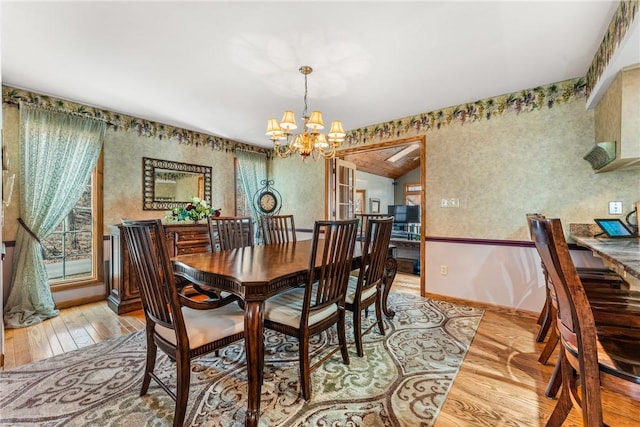 dining area with a notable chandelier, baseboards, and light wood-style floors