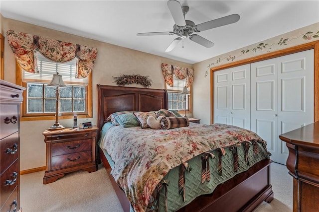 bedroom with a closet, light carpet, baseboards, and a ceiling fan