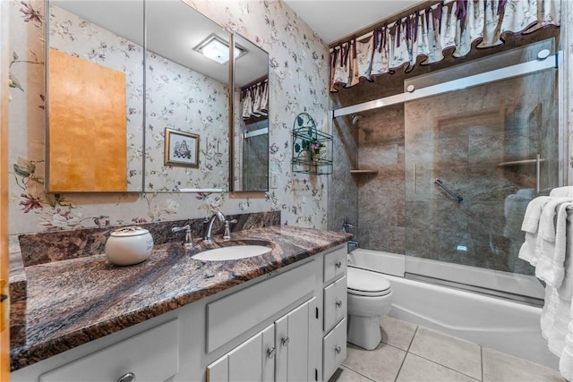 bathroom with vanity, shower / bath combination with glass door, wallpapered walls, tile patterned flooring, and toilet