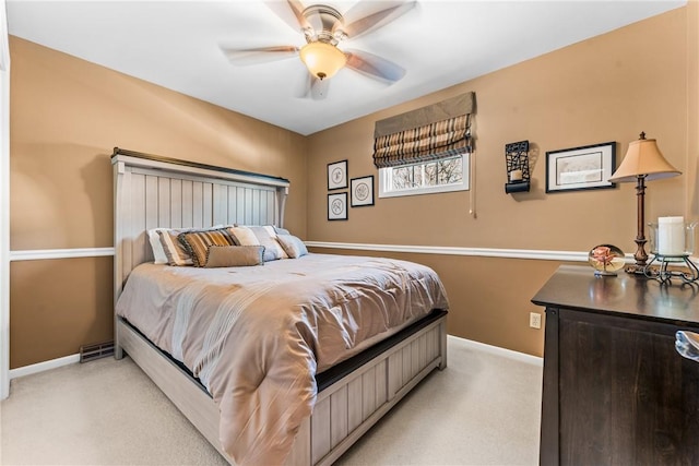 bedroom featuring light colored carpet, a ceiling fan, and baseboards