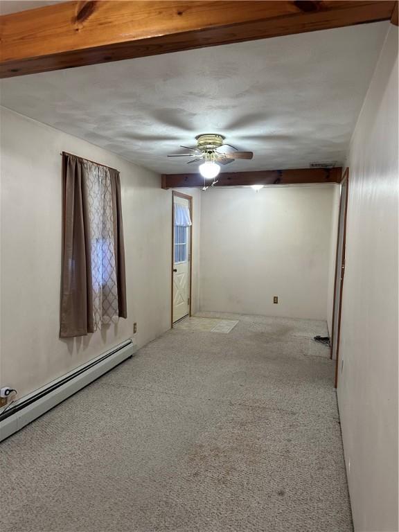 unfurnished room featuring a ceiling fan, baseboard heating, and light carpet