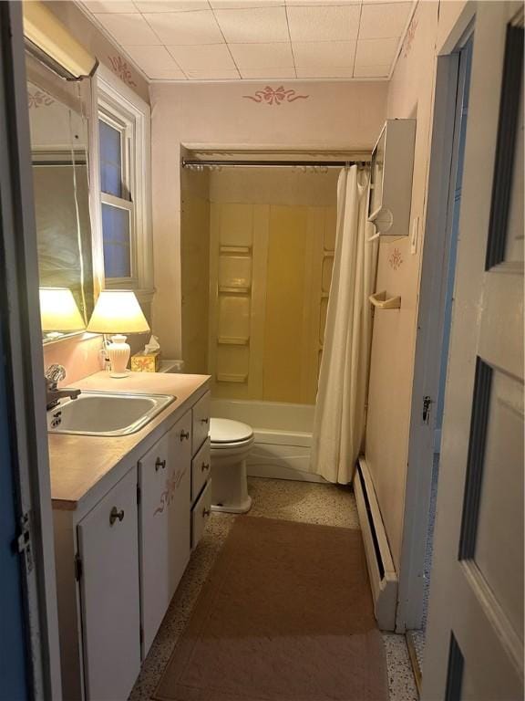 full bath featuring toilet, vanity, a baseboard heating unit, and shower / tub combo