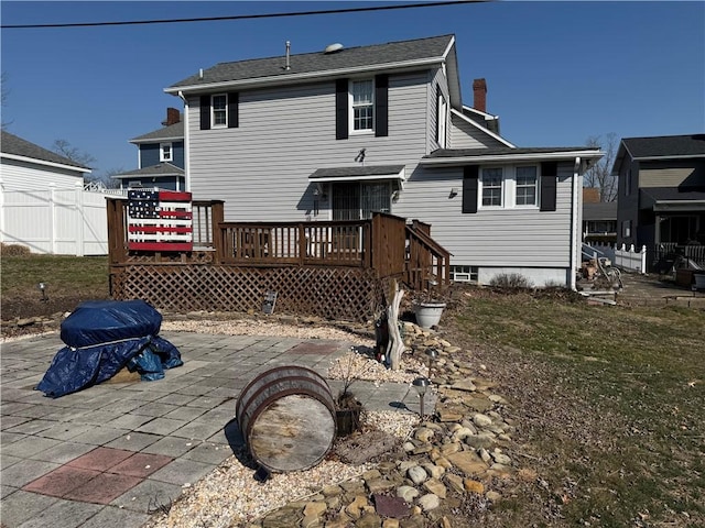 back of house with a wooden deck, fence, and a patio area