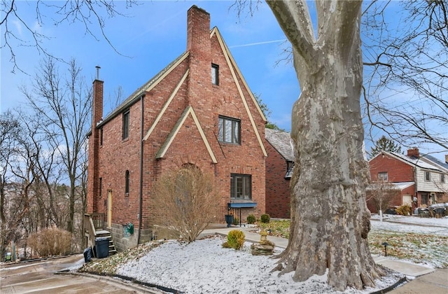 exterior space with brick siding and a chimney