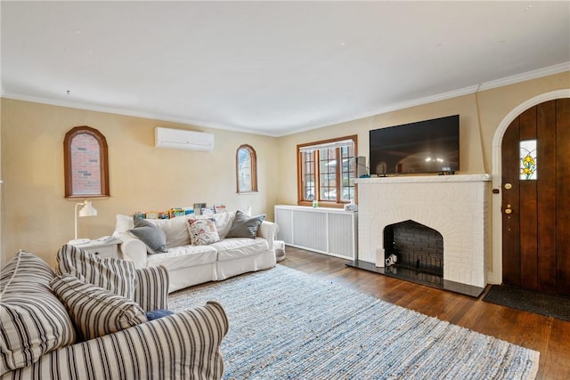 living area with wood finished floors, arched walkways, ornamental molding, a wall mounted air conditioner, and a brick fireplace